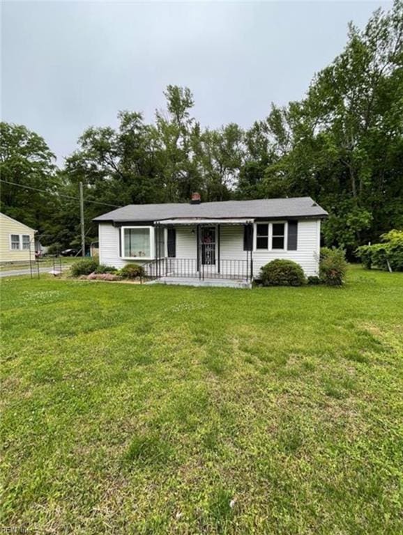 ranch-style home featuring a front lawn and covered porch