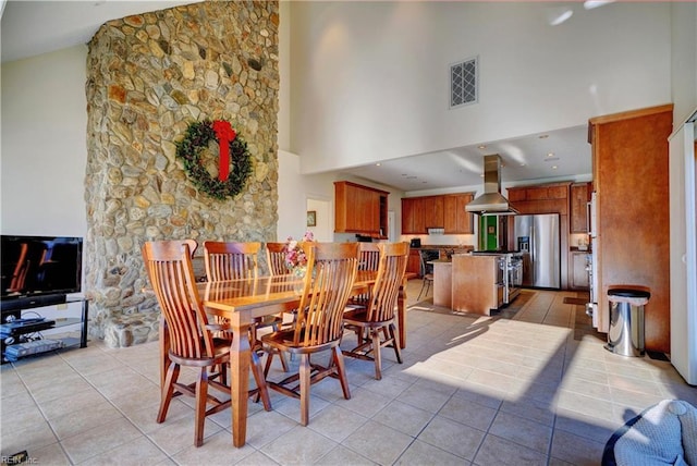 tiled dining space featuring a high ceiling