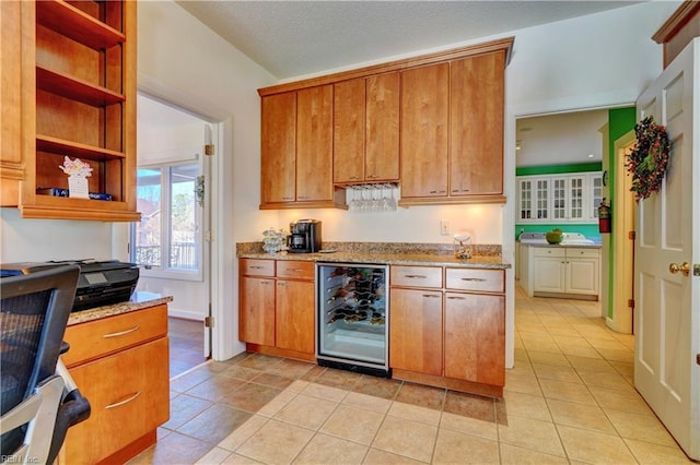 kitchen with wine cooler, light stone countertops, and light tile patterned flooring