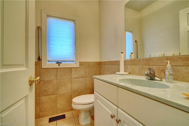 bathroom with vanity, tile patterned floors, toilet, and tile walls