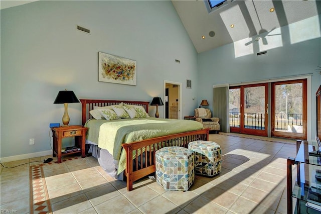 tiled bedroom featuring ceiling fan, access to exterior, a skylight, and high vaulted ceiling