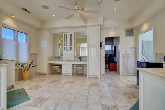 bathroom featuring ceiling fan, tile patterned flooring, and tile walls