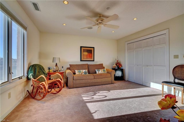 carpeted living room featuring a wealth of natural light and ceiling fan