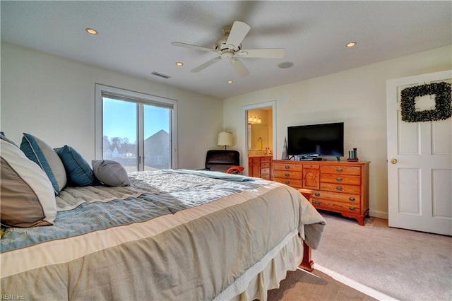 bedroom with connected bathroom, light colored carpet, access to exterior, and ceiling fan