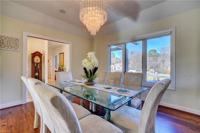 dining space featuring dark hardwood / wood-style floors and an inviting chandelier