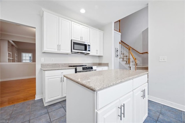 kitchen with appliances with stainless steel finishes, a center island, and white cabinets