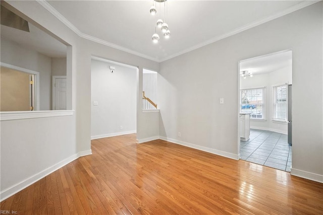 spare room featuring crown molding and light hardwood / wood-style floors