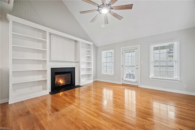 unfurnished living room featuring high vaulted ceiling, built in features, ceiling fan, and light hardwood / wood-style flooring