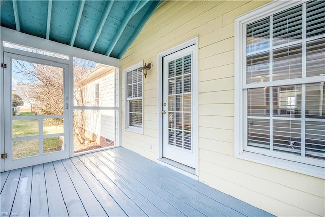 unfurnished sunroom featuring vaulted ceiling