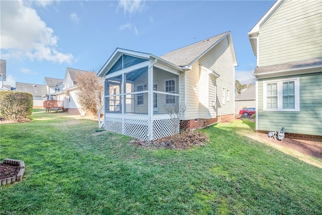 back of property featuring a lawn and a sunroom