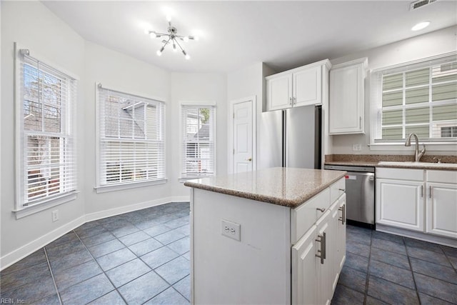 kitchen featuring a kitchen island, white cabinetry, appliances with stainless steel finishes, and sink