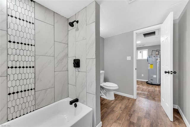 bathroom featuring wood-type flooring, toilet, tiled shower / bath combo, and water heater