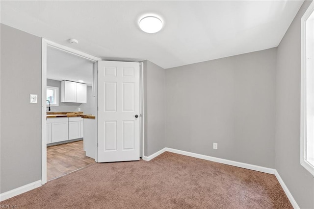 bonus room featuring sink and light carpet