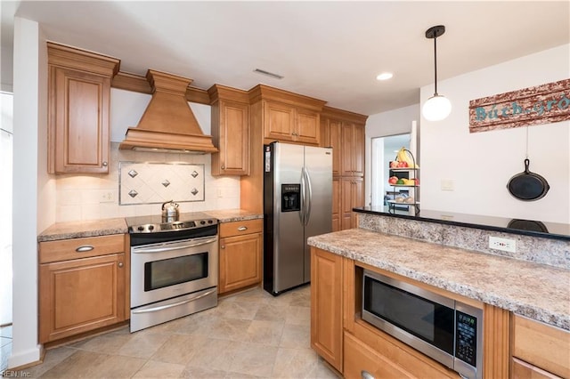 kitchen with tasteful backsplash, hanging light fixtures, custom range hood, stainless steel appliances, and light stone countertops