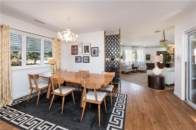 dining space with wood-type flooring and a chandelier