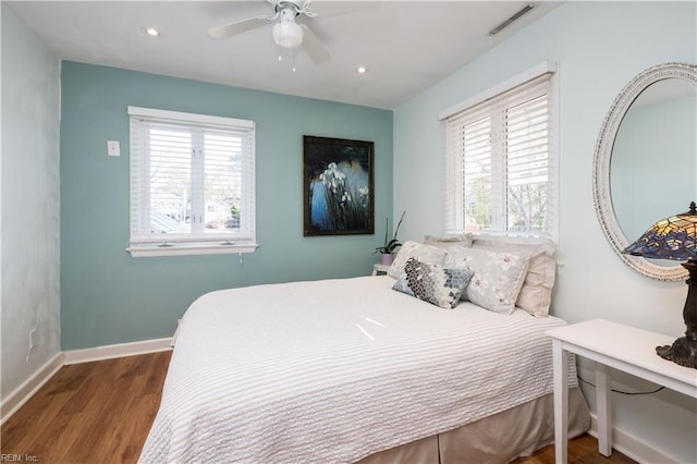 bedroom featuring multiple windows, wood-type flooring, and ceiling fan