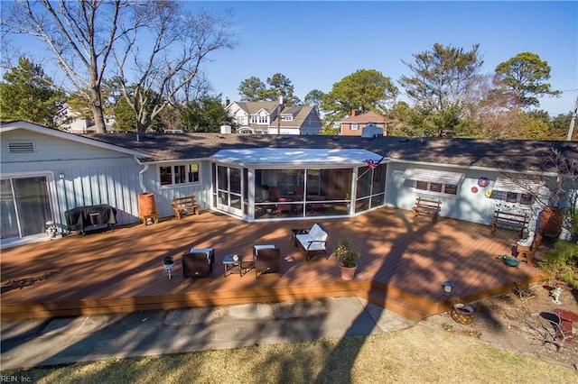 back of property with a sunroom and a deck