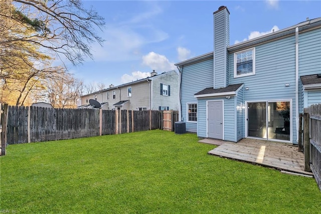 rear view of property featuring a wooden deck, cooling unit, and a lawn