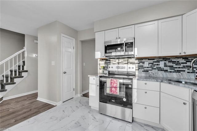 kitchen with white cabinetry, sink, tasteful backsplash, and appliances with stainless steel finishes