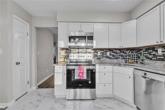 kitchen featuring sink, stainless steel appliances, light stone countertops, decorative backsplash, and white cabinets