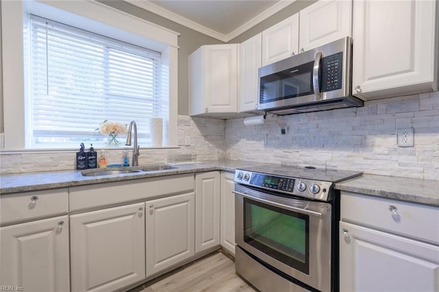 kitchen featuring sink, crown molding, appliances with stainless steel finishes, light stone counters, and white cabinets