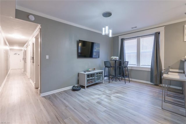 interior space featuring crown molding and light hardwood / wood-style flooring