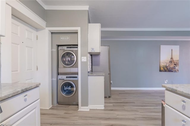 washroom with crown molding, stacked washer / drying machine, and light hardwood / wood-style floors