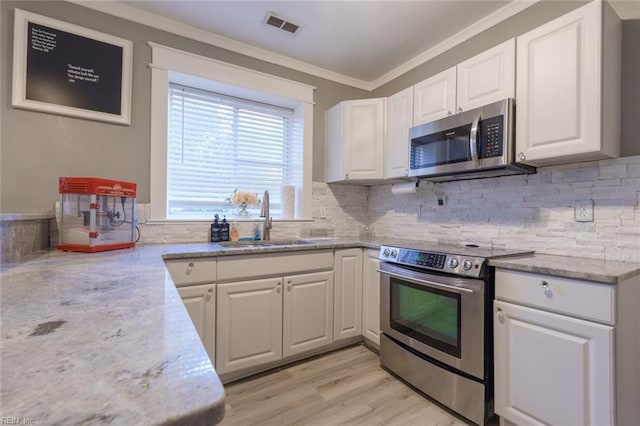 kitchen featuring white cabinetry, sink, stainless steel appliances, and light stone countertops