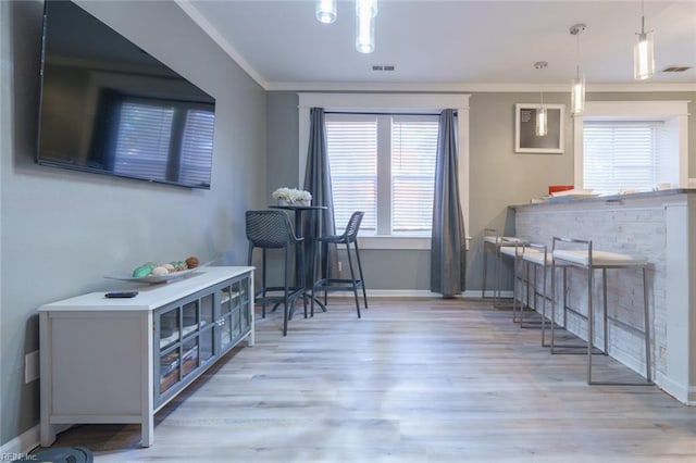 interior space featuring ornamental molding and light wood-type flooring