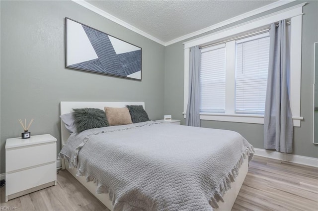 bedroom featuring ornamental molding, a textured ceiling, and light wood-type flooring