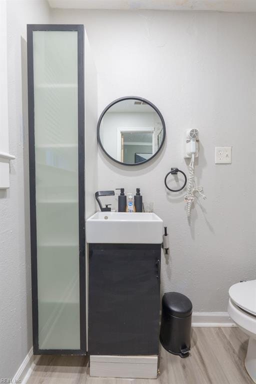 bathroom with vanity, wood-type flooring, and toilet