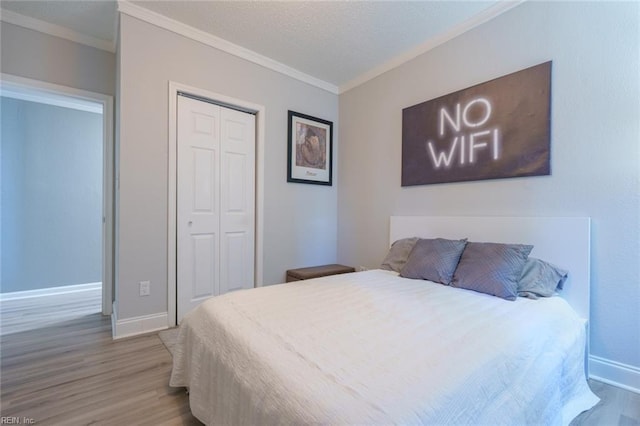 bedroom featuring crown molding, a closet, and hardwood / wood-style flooring