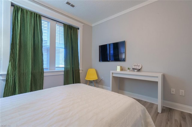 bedroom featuring crown molding and light hardwood / wood-style flooring