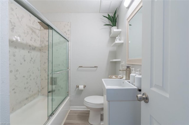 full bathroom featuring vanity, toilet, combined bath / shower with glass door, and wood-type flooring