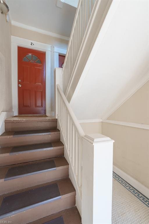 stairs featuring tile patterned flooring and crown molding