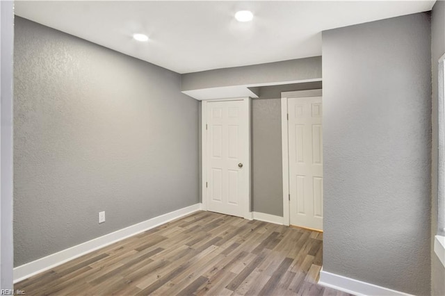 unfurnished bedroom with wood-type flooring and a closet