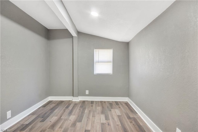 empty room featuring lofted ceiling and hardwood / wood-style flooring