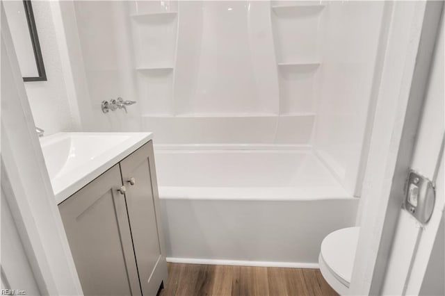 full bathroom with shower / bathtub combination, wood-type flooring, toilet, and vanity