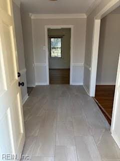 hall with tile patterned floors and ornamental molding