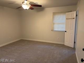 unfurnished room with ceiling fan and dark colored carpet