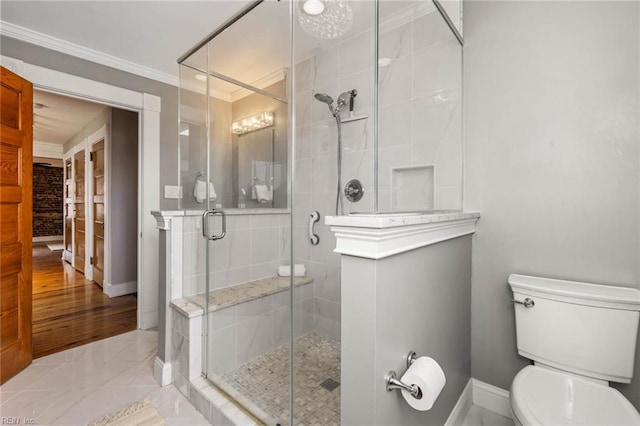 bathroom with walk in shower, ornamental molding, and toilet