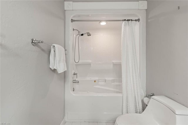 bathroom featuring shower / tub combo and toilet