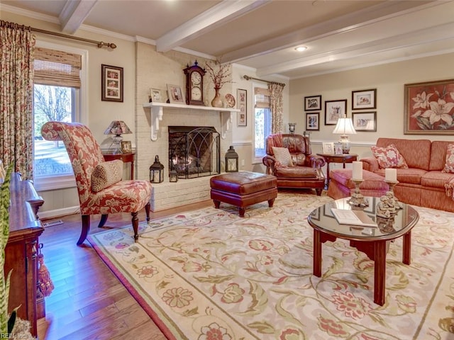 living room featuring hardwood / wood-style floors, beam ceiling, plenty of natural light, and ornamental molding