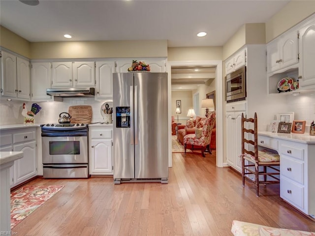 kitchen featuring decorative backsplash, stainless steel appliances, white cabinets, and light wood-type flooring