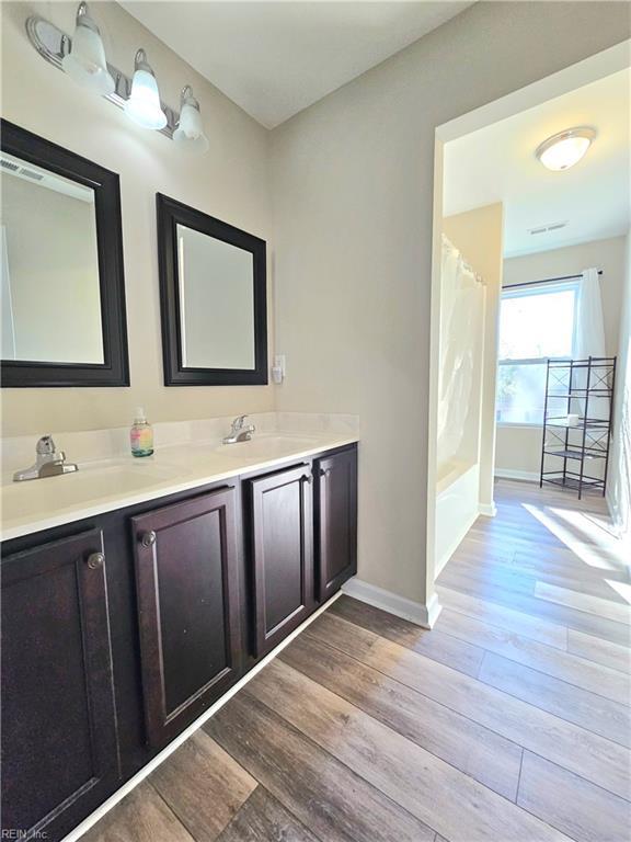 bathroom with vanity, shower / tub combo, and wood-type flooring