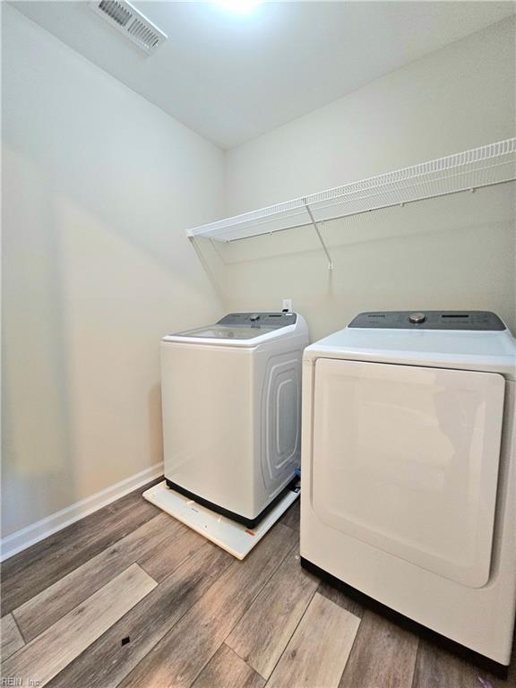 laundry area with hardwood / wood-style floors and washer and dryer