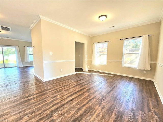 spare room with dark wood-type flooring, crown molding, and a wealth of natural light