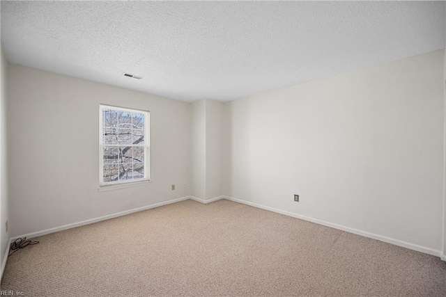 unfurnished room featuring carpet and a textured ceiling