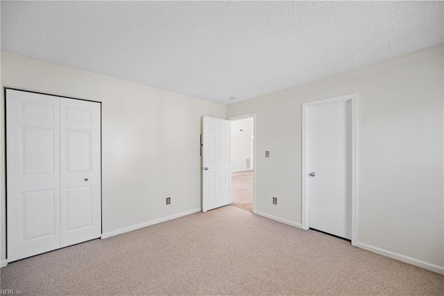 unfurnished bedroom with a closet, light carpet, and a textured ceiling