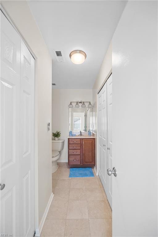 bathroom featuring vanity, tile patterned floors, and toilet